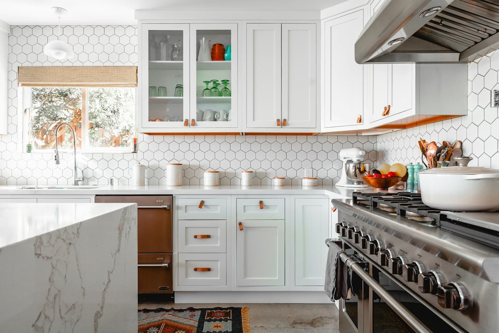 Kitchen renovation inspiration with cabinetry, tile, counters, and lighting