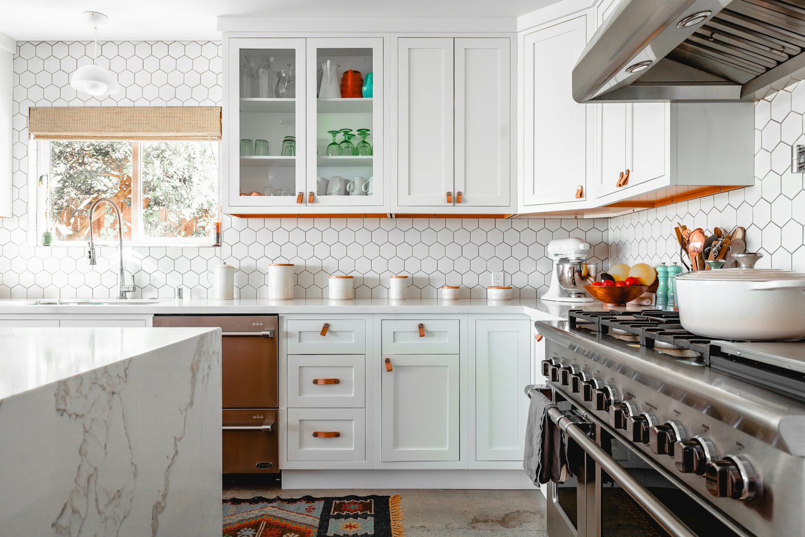 Kitchen renovation inspiration with cabinetry, tile, counters, and lighting